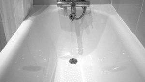 close-up photo of a bathtub focusing on the drain with drain stopper in it