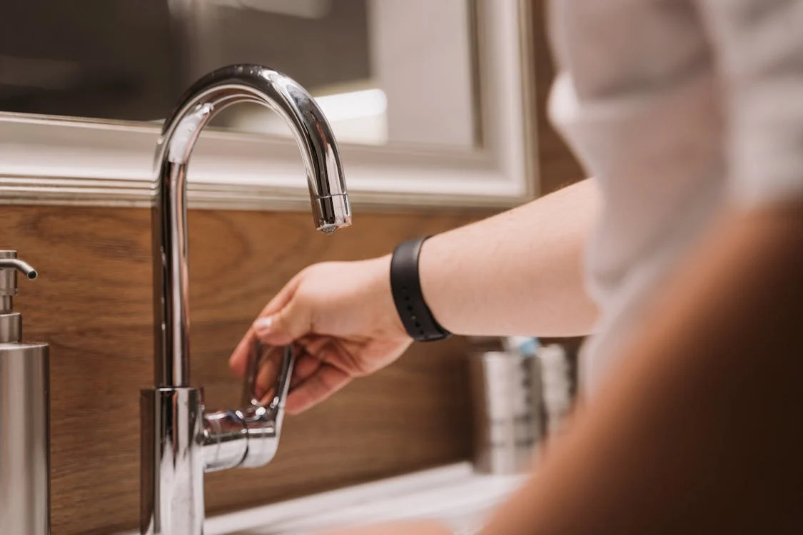 A local plumber checking a bathroom faucet