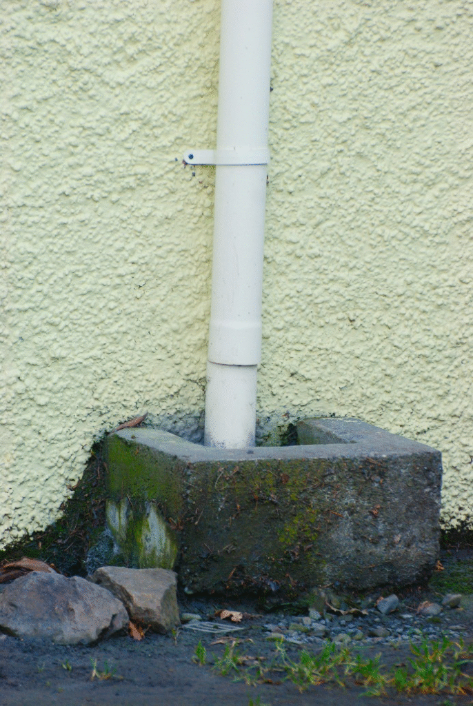 A white pipe leading to a drain
