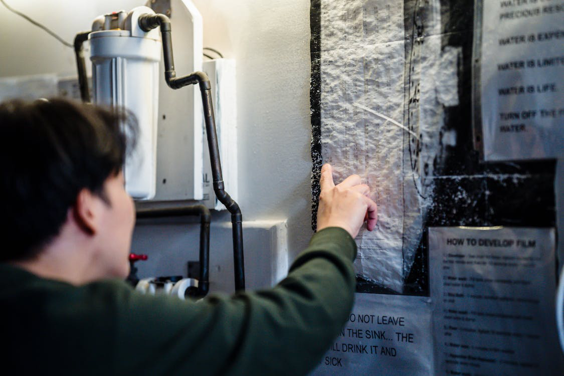 A person looking over a water heater.