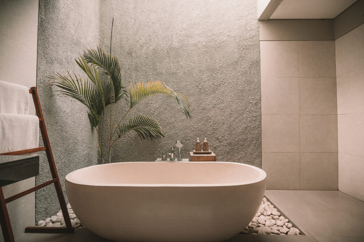 A bathtub next to a plant