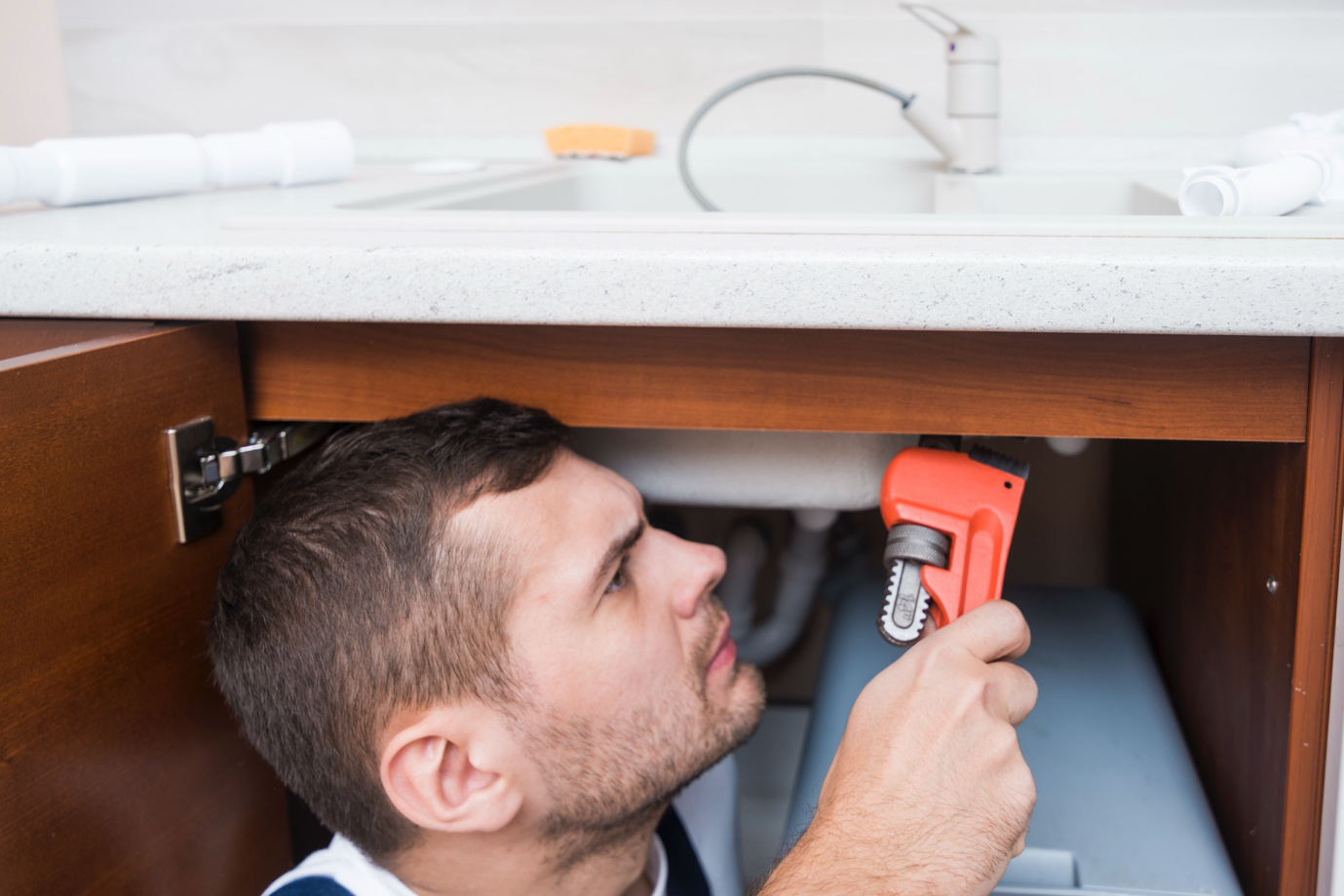 Under-sink plumbing lines are being upgraded in a Cambridge kitchen