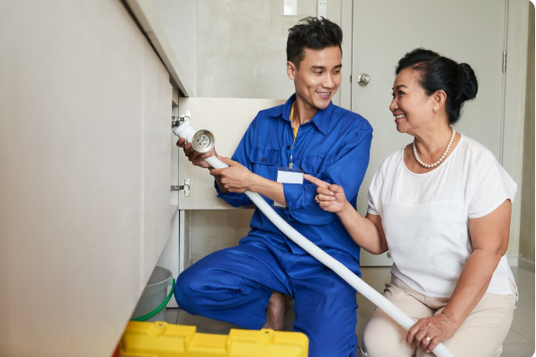 Plumber diagnosing a clogged pipe to stop small drain problems from becoming costly disasters. 