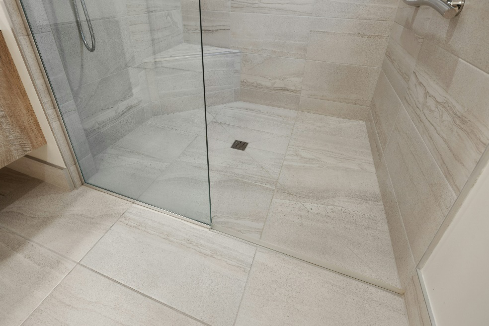 Shower drain inside a stall that may be causing gurgling sounds from underlying plumbing issues