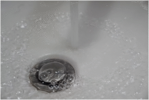 Sink with water bubbling due to stubbornly clogged drains