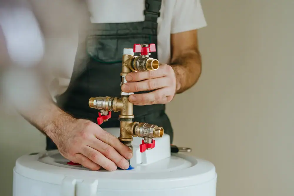 A man working on a water heater.